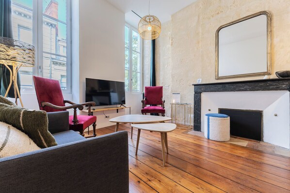 A modern living room with a fireplace, a television, and a large window.
