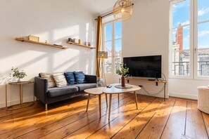 Un salon moderne avec un canapé, une table basse et un téléviseur.