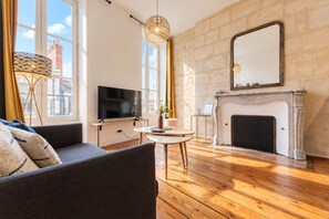 Ein Wohnzimmer mit Kamin, Fernseher und einer Couch.