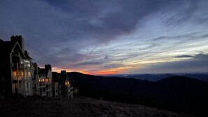 A large, multi-story building with a prominent entrance and multiple windows, situated on a hill overlooking a mountainous landscape. - Sauna, dog friendly Amazing views to ski slopes (Wintergreen Resort)