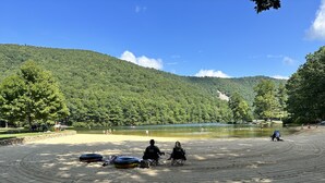 A sandy beach with people and boats, surrounded by forested hills. - Sauna, dog friendly Amazing views to ski slopes (Wintergreen Resort)