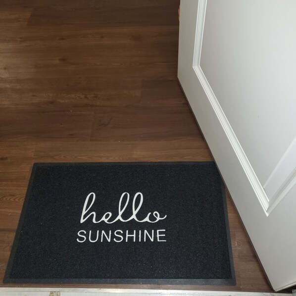 A black doormat with the words "hello SUNSHINE" in white. - Stylish and Spacious, Close to the Hospital (Fort Wayne)