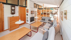 Um interior moderno com uma mesa de jantar de madeira, um sofá e uma área de cozinha com armários de madeira e um fogão.