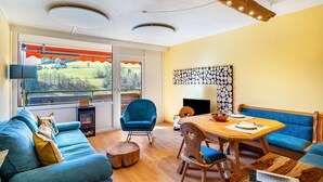 Een moderne woonkamer met een bank, een eettafel en een open haard.