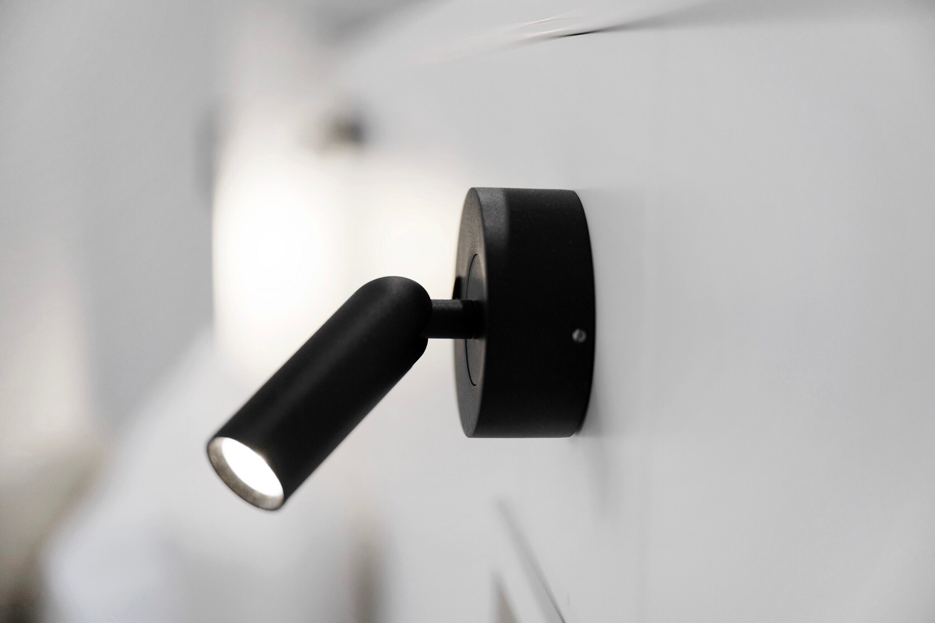 A wall-mounted light fixture with a cylindrical shape and a visible switch.