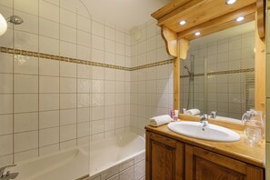 Une salle de bain avec une baignoire, un lavabo et un miroir.