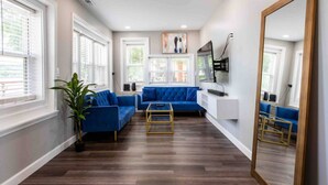 A modern living room with a blue sofa set, a wooden coffee table, and a large mirror. - Family/Pet-Friendly Riverside Home w/Amazing Views (Prospect)