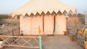 A tent-like structure with a peaked roof, surrounded by scaffolding and potted plants. - Ram Rann Resort (Bhachau)