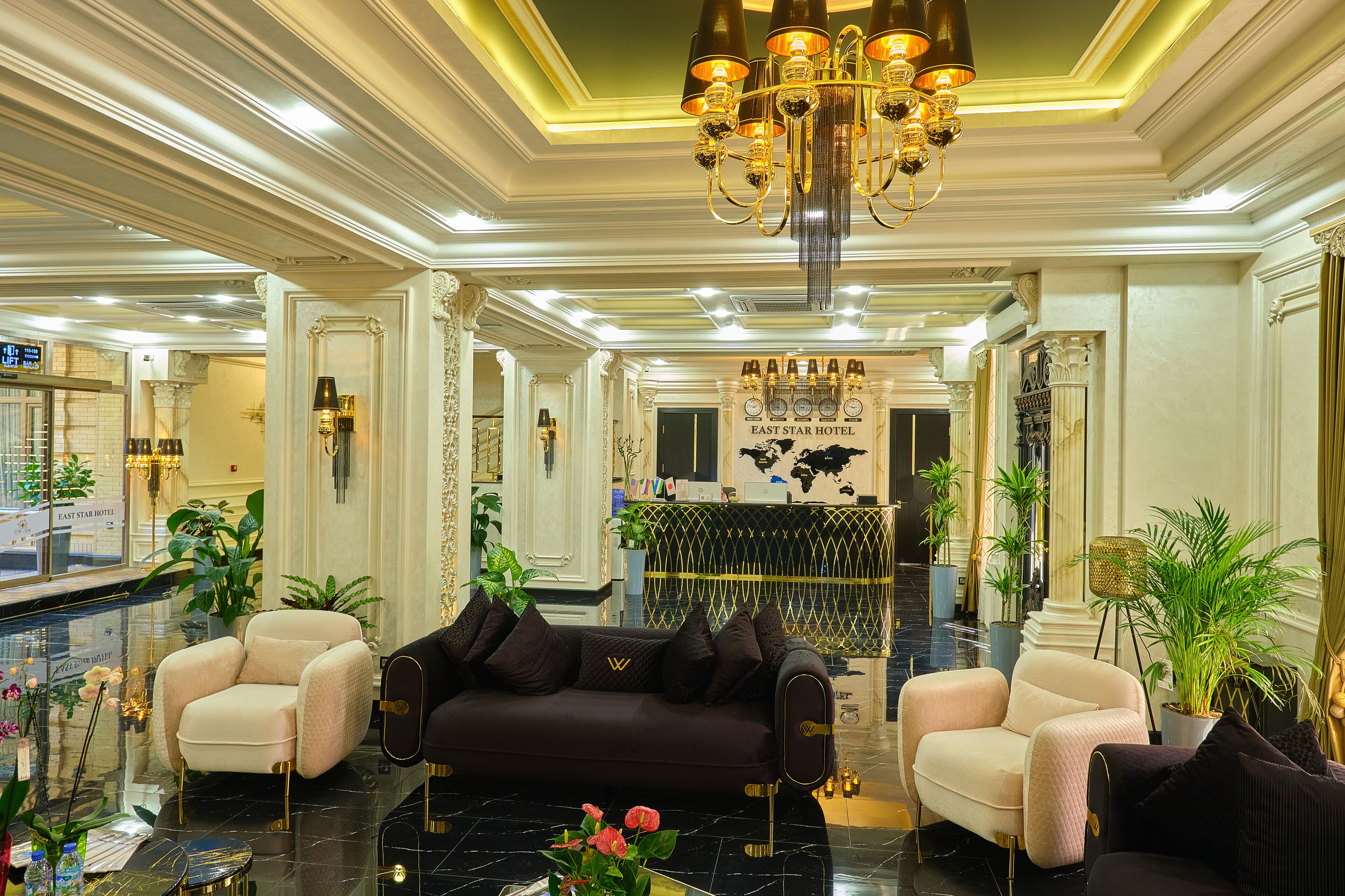 Un hall d’hôtel luxueux, agrémenté d’un imposant lustre, de fauteuils confortables et d’un comptoir d’accueil.