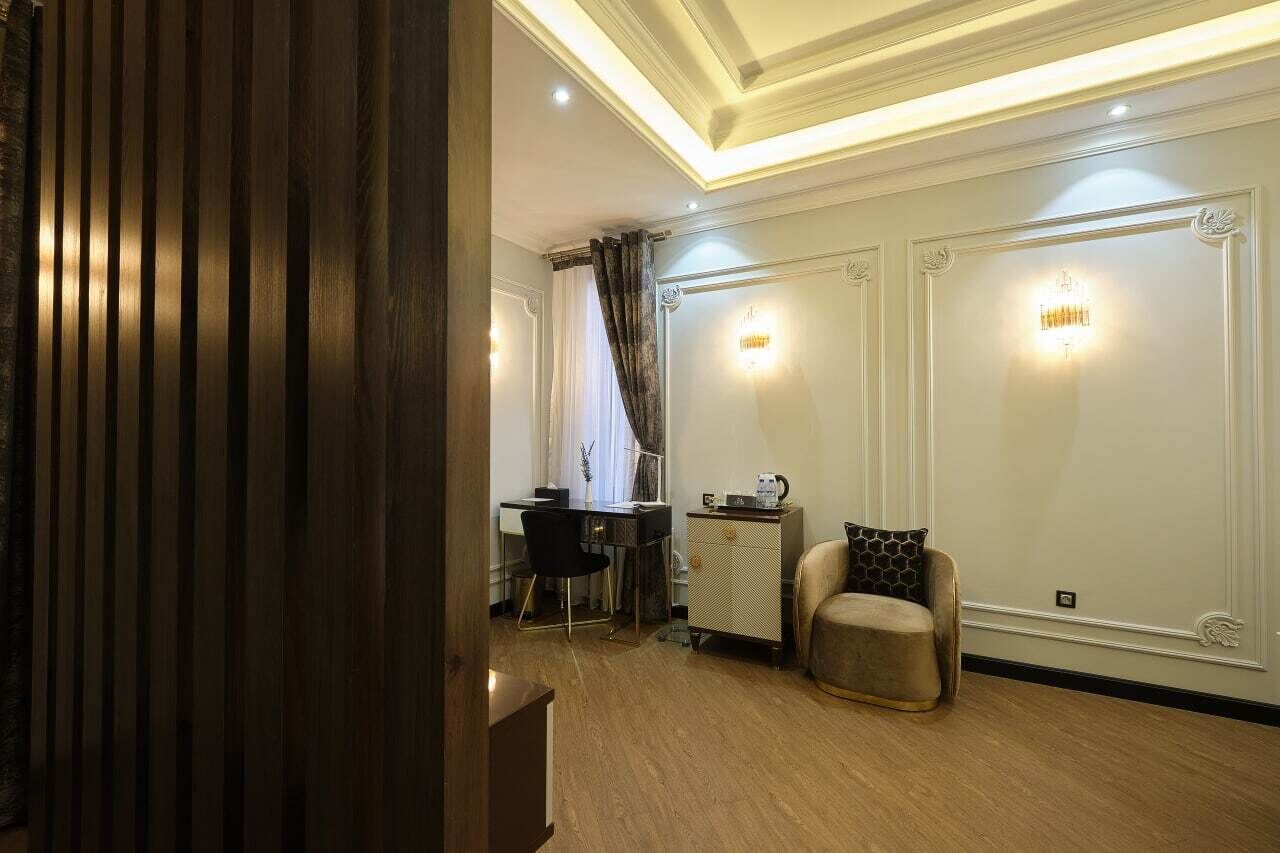 Een kamer met een houten vloer, een bureau met stoel, een bank en een kast.
