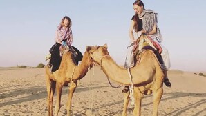 Two people riding camels in a desert. - Desert Safari Camping Jaisalmer  (Jaisalmer)