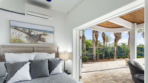 Ein Schlafzimmer mit einem Bett, einem Nachttisch, einer Lampe und einem Bild von einer Strandlandschaft.