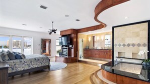 Ein modernes Schlafzimmer mit Bett, Fernseher und Kamin.