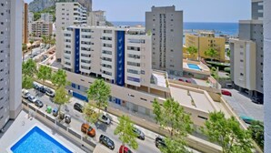 A high-rise residential building with multiple balconies, a swimming pool, and a view of the sea and a mountain in the background. - La Luz 12 by Interhome (Calpe/Calp)