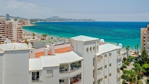 A coastal hotel with balconies overlooking the sea, a beach, and a cityscape in the background. - La Luz 12 by Interhome (Calpe/Calp)