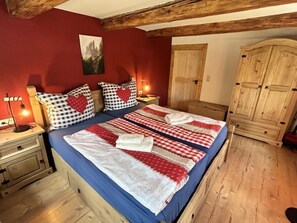 Ein Schlafzimmer mit einem großen Bett, einem Holz-Kopfteil und einem Kleiderschrank.