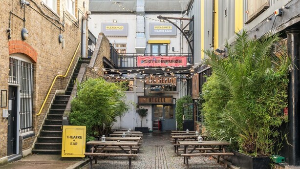 A narrow cobblestone alley with a staircase leading to a building labeled "Pleasure Theatre & Bar". - Super 1BD Garden Flat Islington London (London)