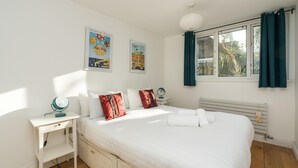 A bedroom with a large bed, a desk, and a window with curtains. - Super 1BD Garden Flat Islington London (London)