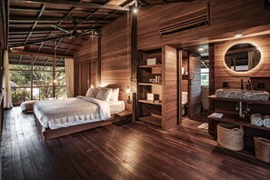 Une chambre spacieuse avec un grand lit, des murs en bois et une coiffeuse intégrée avec un miroir.