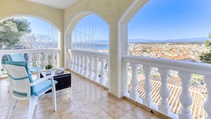 Un balcón con vista a un paisaje urbano y montañas.