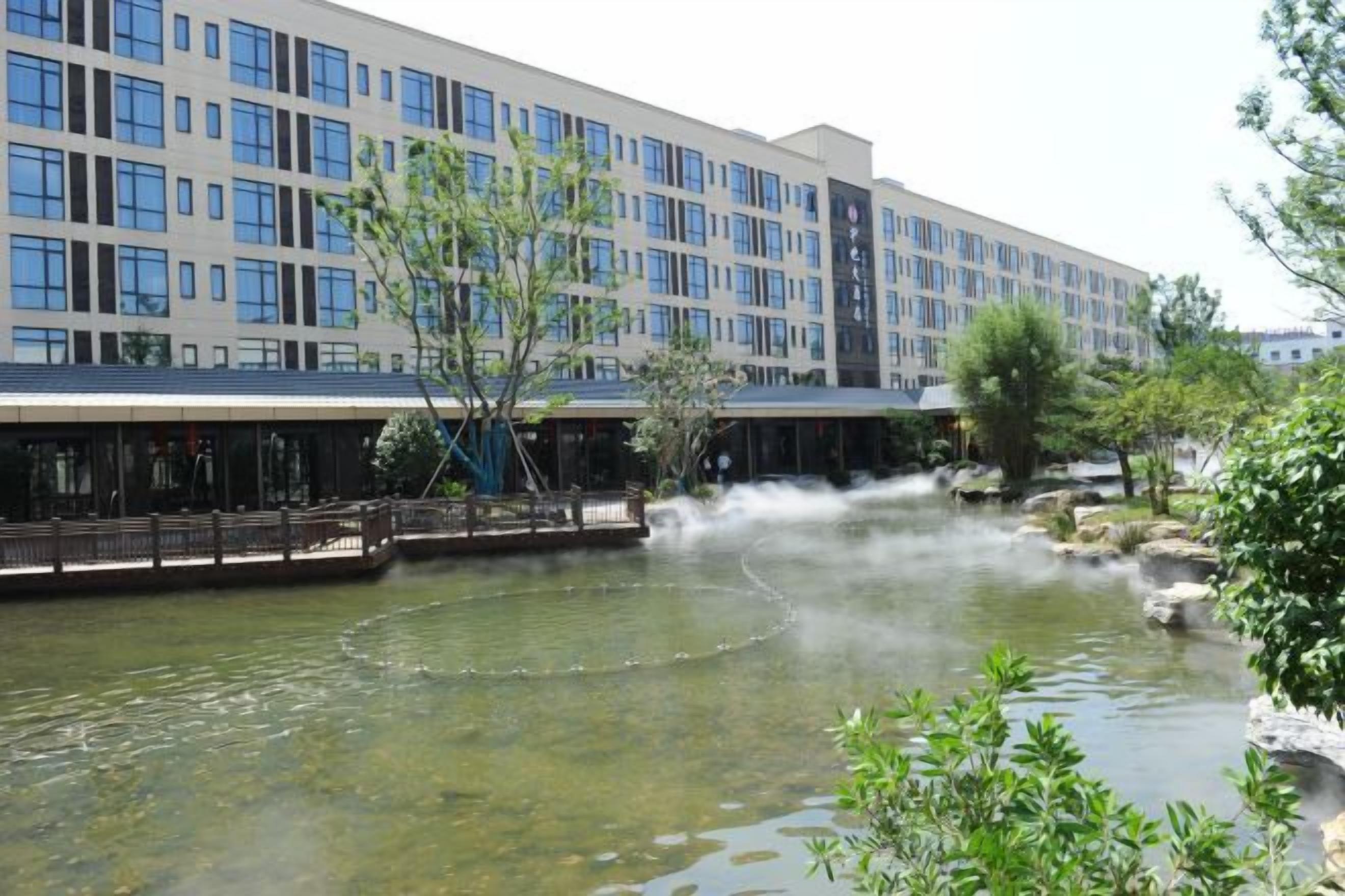 A hotel with a river, a bridge, and a building with multiple windows.