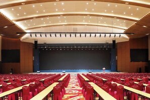 A large auditorium with rows of red chairs and a stage at the front. - Heye Hotel (Anji)