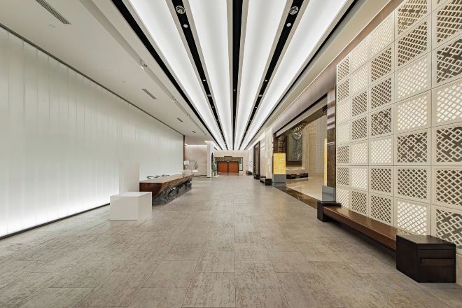 A modern interior with a long corridor, a reception desk, and a decorative partition.