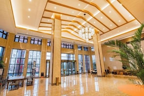 A spacious lobby with a high ceiling, large windows, and a central chandelier. - Heye Hotel (Anji)