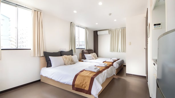 A hotel room with three beds, a large window, and a refrigerator. - Comfy Stay Kiyokawa (Nara)