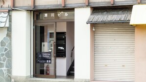 A building entrance with a sign that reads "Comfy Stay Kyoto" and a fire extinguisher mounted on the wall. - Comfy Stay Kiyokawa (Nara)