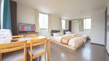 Relax in a spacious room with a large bed, wooden desk, and television.