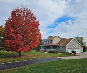 A two-story house with a front porch, a garage, and a well-maintained lawn.