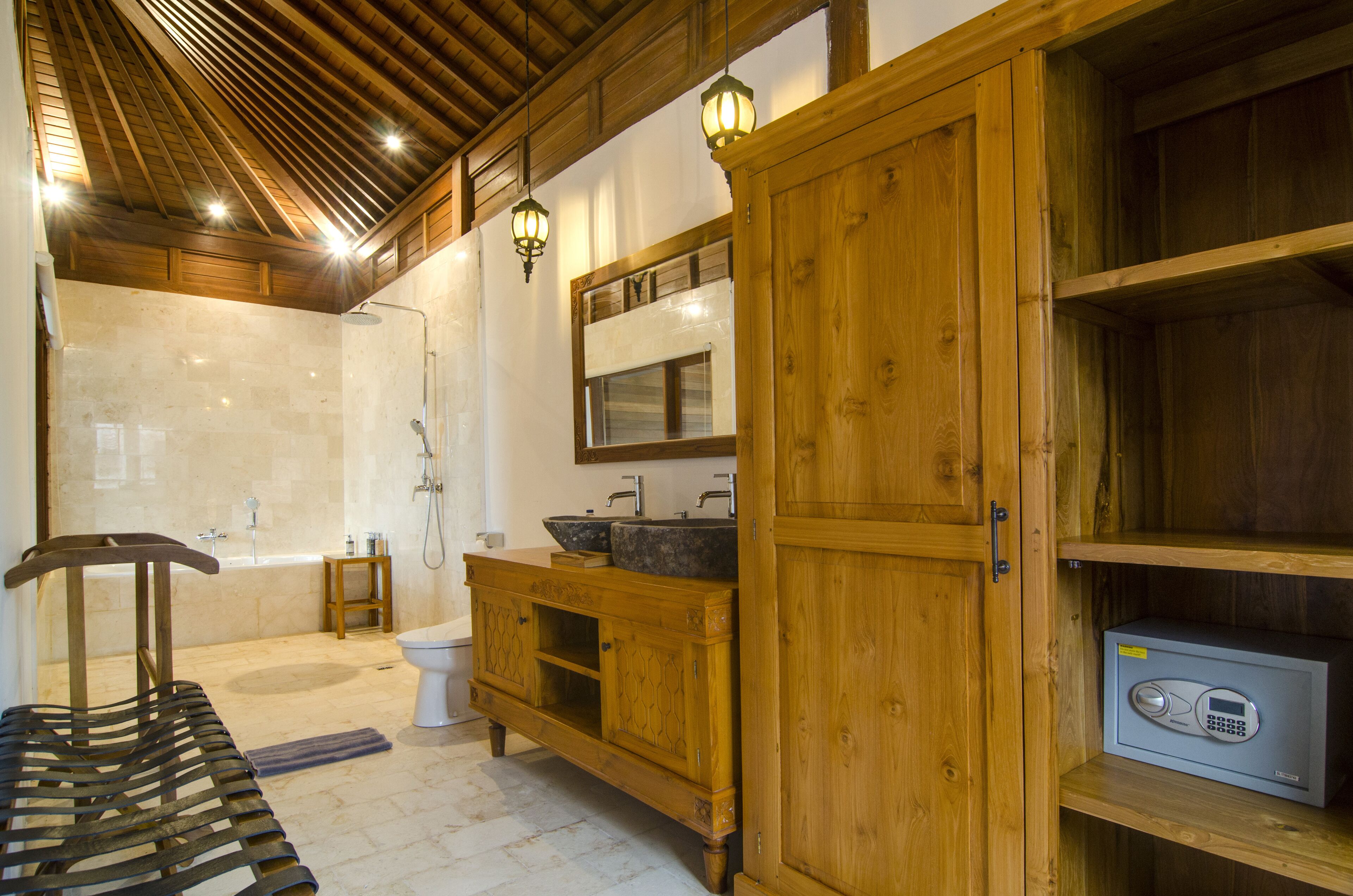 Une salle de bain avec un meuble-lavabo en bois, une baignoire et des toilettes.