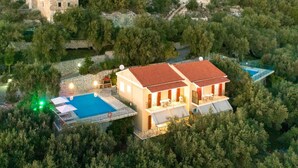 A two-story house with a red-tiled roof, a swimming pool, and a stone wall. - Villa Kalithea in Nisaki (Corfu)