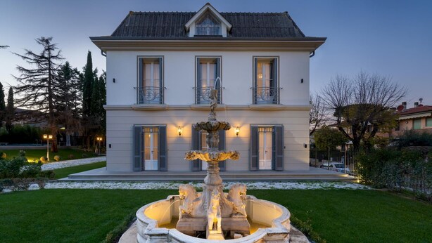 A large, two-story building with a symmetrical facade, a central entrance, and a decorative fountain in the front garden. - Villa Irma 10 (Casciana Terme Lari)