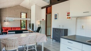 Una cocina moderna con comedor, sofá y televisor.