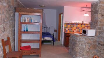Cozy room with a stone wall, wooden bookshelf, and a comfortable bed.