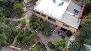 A two-story building with a flat roof, a balcony, and a patio area with outdoor furniture.