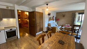 Una cocina acogedora con armarios de madera, una mesa de comedor y un horno empotrado.