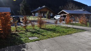 Zona residencial con casas, una calle pavimentada y un área verde con árboles.