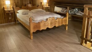 Un llit de fusta en una habitació amb parets i terres de fusta.