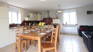 A spacious kitchen with a dining table set for six, wooden chairs, and a modern pendant light. - Restored Traditional House - Pets Allowed, WIFI, Enclosed Garden (Landisacq)