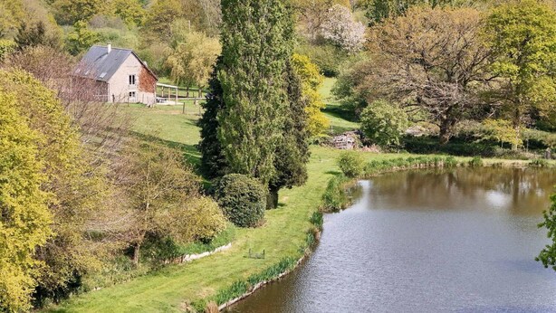 A rural landscape with a house near a river, surrounded by trees and greenery. - Restored Traditional House - Pets Allowed, WIFI, Enclosed Garden (Landisacq)