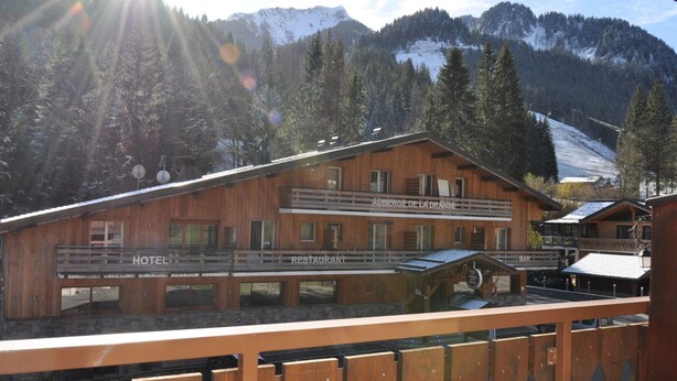 A wooden building with a restaurant and bar on the upper level, and a hotel on the lower level. - Cozy apartment near slopes with balcony and parking (Châtel)