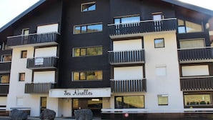 A multi-story building with balconies, a sign reading "Les Airelles," and large windows. - Comfortable two-room with balcony and parking, near ski lifts (La Chapelle-d'Abondance)