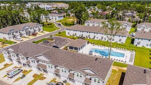 A residential area with detached houses, a swimming pool, and a parking lot.