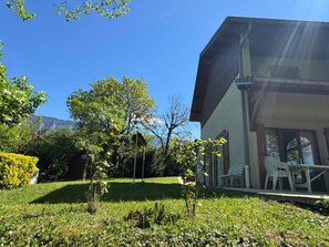 Un edificio moderno con un portico coperto e un prato.