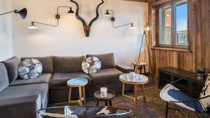 A cozy living room with a sectional sofa, a coffee table, and a unique wall-mounted light fixture.