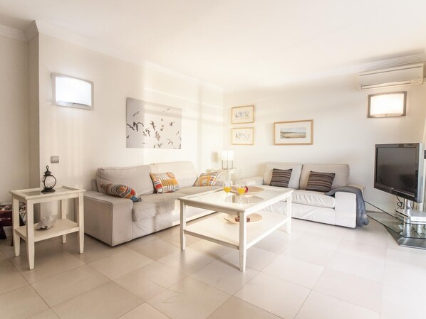 A modern living room with two sofas, a coffee table, and a TV.