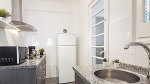 Una cocina moderna con encimeras de granito, electrodomésticos de acero inoxidable y un lavamanos doble.